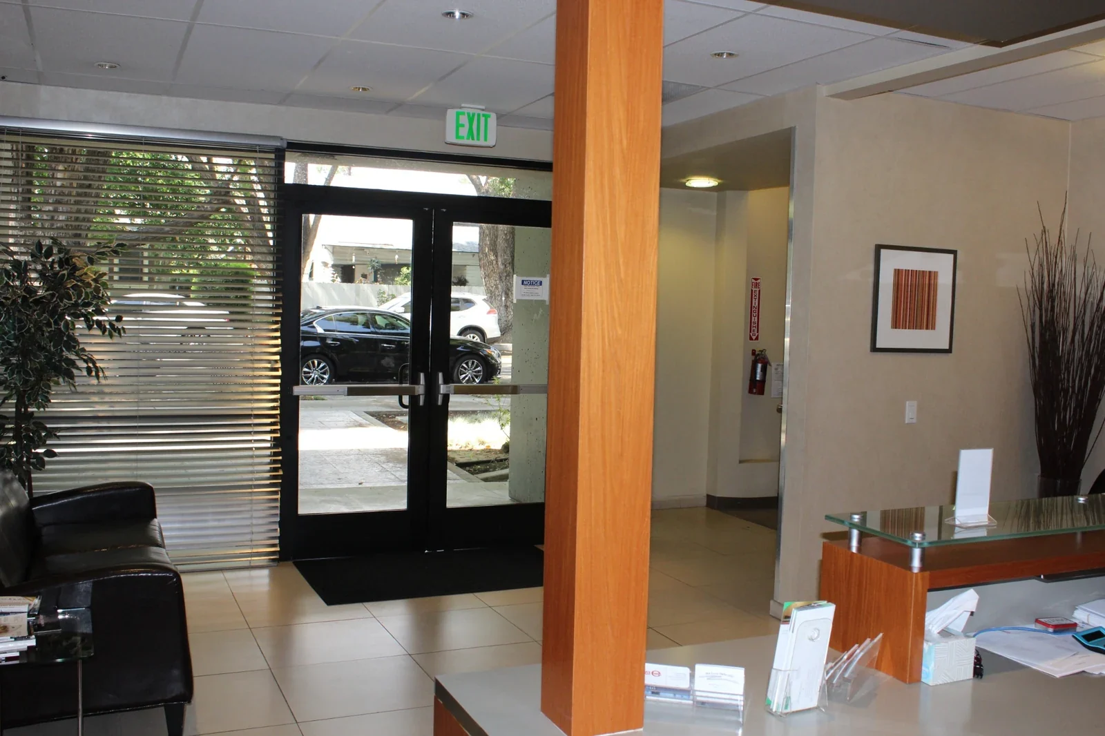 Entry lobby with glass doors, reception counter and seating.